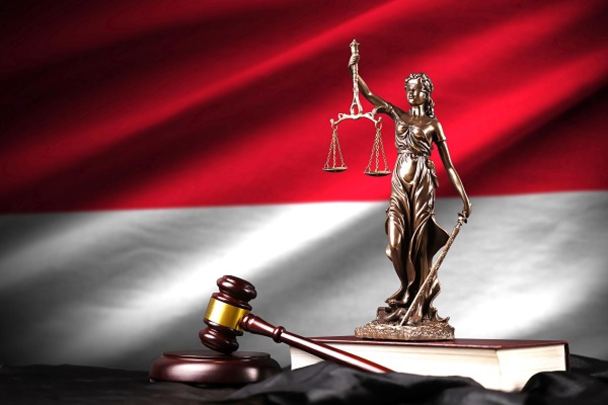 Image of Lady Justice, gavel and law books with Indonesian flag in background by mehaniq41; used under Adobe Education License.