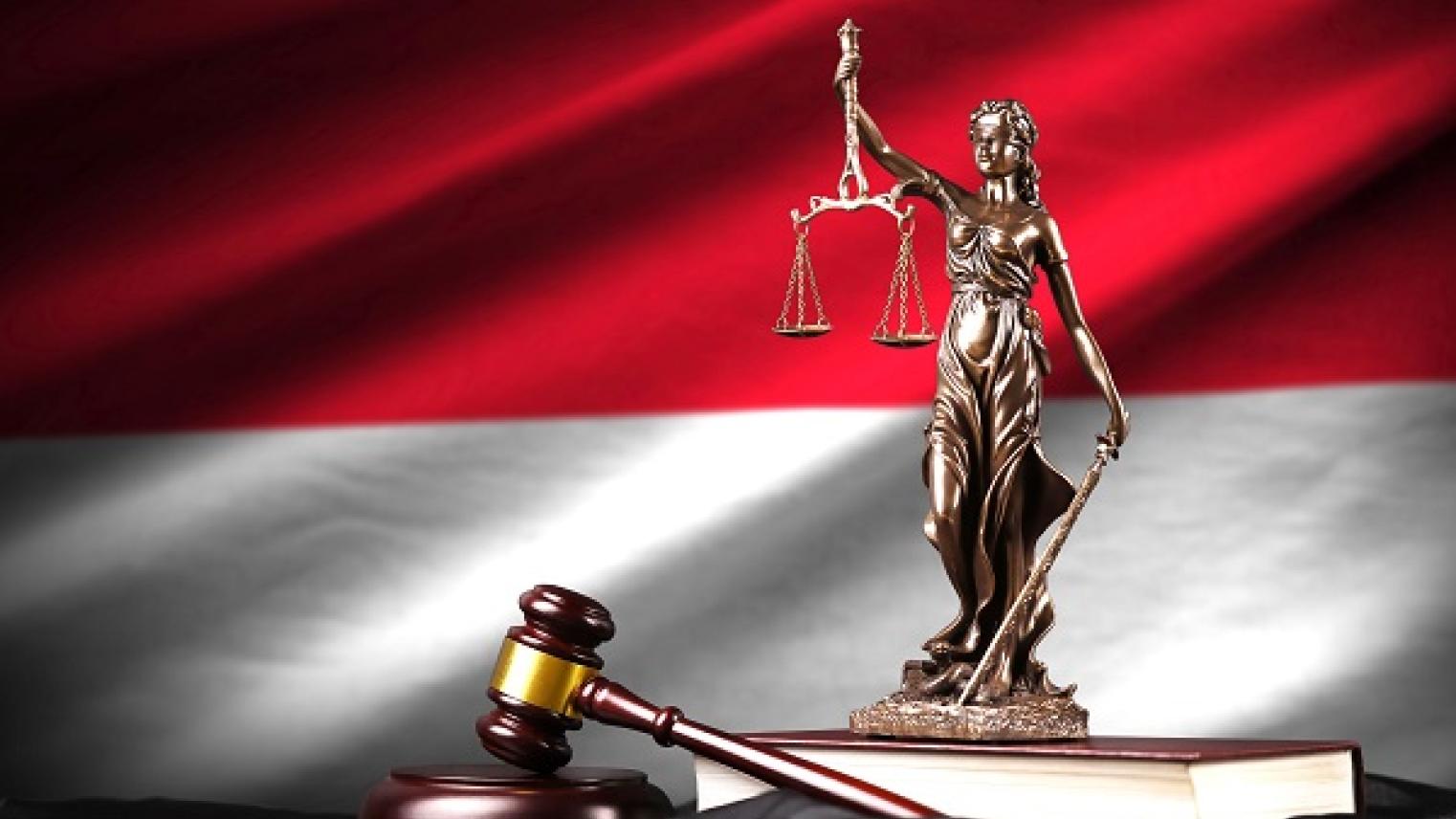 Image of Lady Justice, gavel and law books with Indonesian flag in background by mehaniq41; used under Adobe Education License.